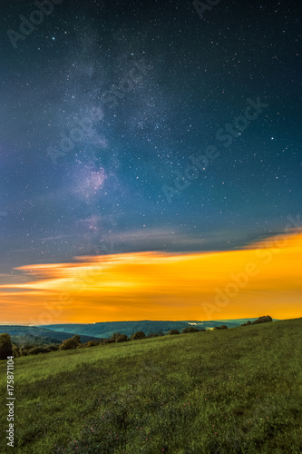 Landscape with the Milky Way as seen from the mountain Katzenbuckel in the Odenwald in Germany.