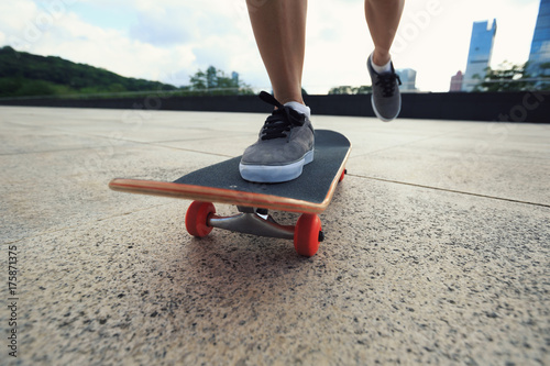 young woman skateboarder riding skateboard at city