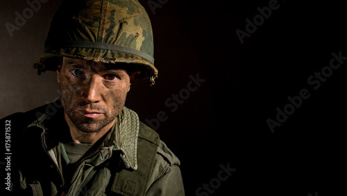 Portrait of combat stressed US Marine (Vietnam War) with face covered in mud.