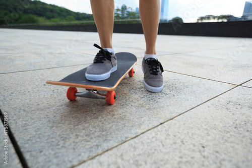 young woman skateboarder riding skateboard at city