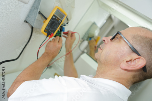electrician measuring voltage of socket in new building closeup