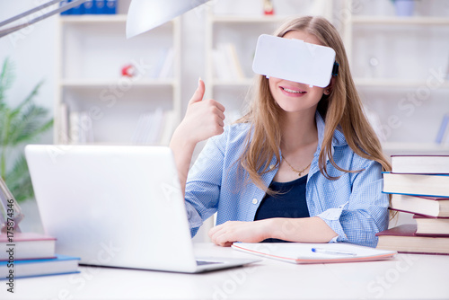 Young female student preparing for exams with VR glasses