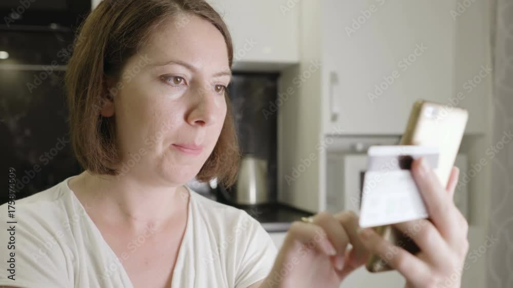 Girl enters credit card number on a smartphone Girl enters credit card number on a smartphone