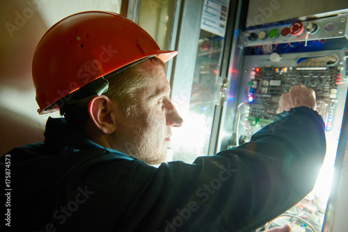 Electrician works with electronic equipment photo