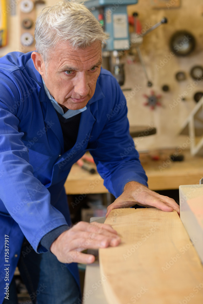 Senior man fitting piece of wood