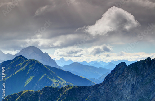 Steep slopes of Carnic Alps main ridge with Monte Peralba   Hochweissstein peak and jagged Julian Alps in the background in morning sunlight  Veneto and Friuli Venezia Giulia regions  Italy  Europe