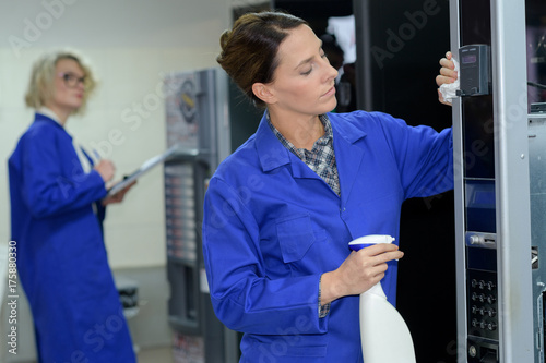 Quadro su tela female cleaner cleaning a vending machine