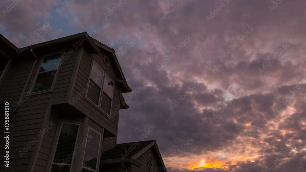 Colorful sunset and moving dramatic clouds over roof of residential suburb home in Happy Valley Oregon 4k ultra high definition time lapse video