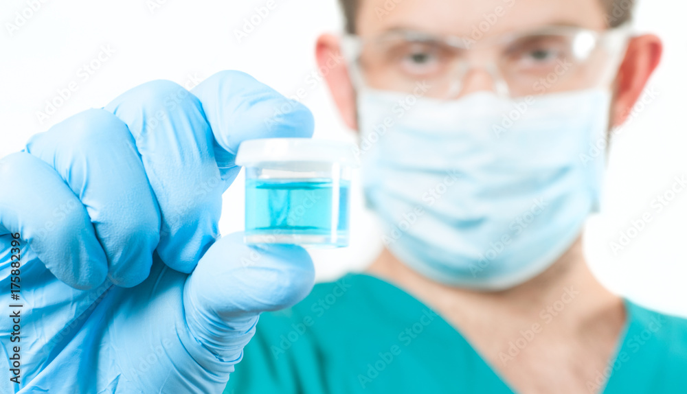 Doctor in protective eyeglasses holding test tube with reagent in lab Doctor in protective eyeglasses holding test tube with reagent in lab