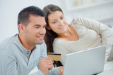 couple with laptop and bank card