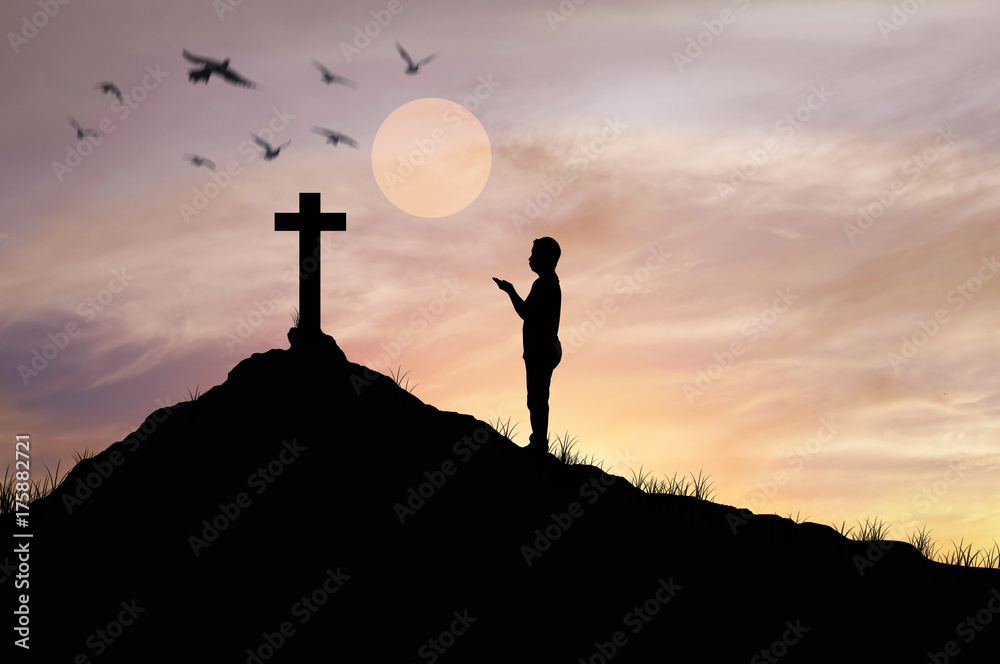 Silhouette man praying in front of cross with faith and belief.