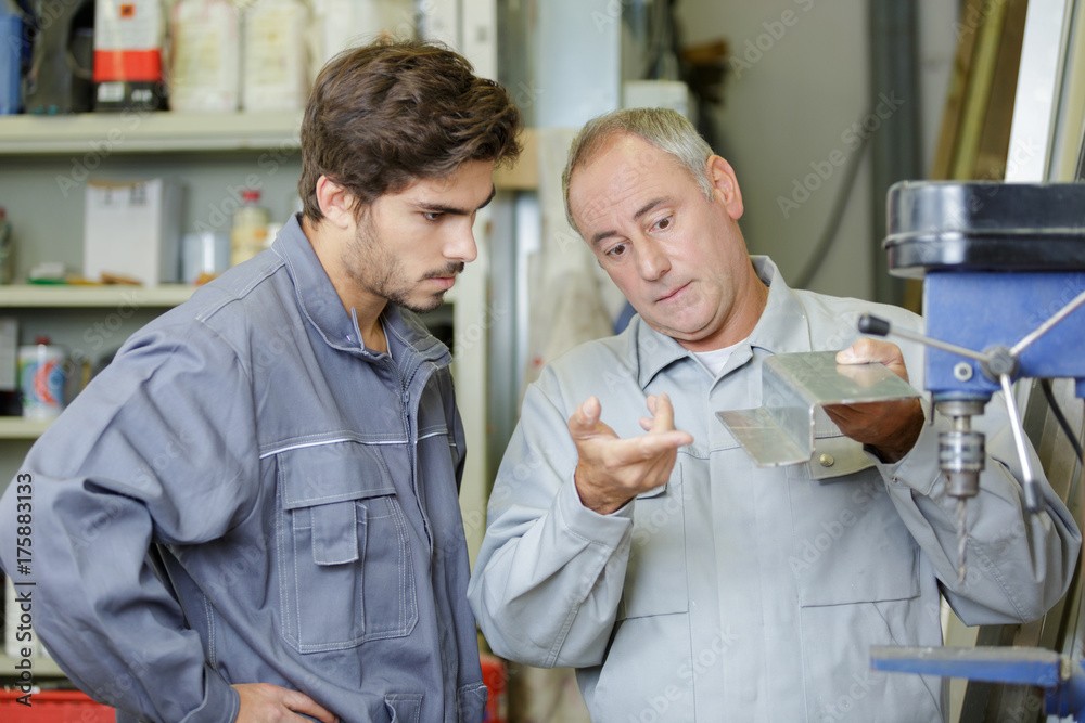 engineer teaching apprentice to use factory machine engineer teaching apprentice to use factory machine