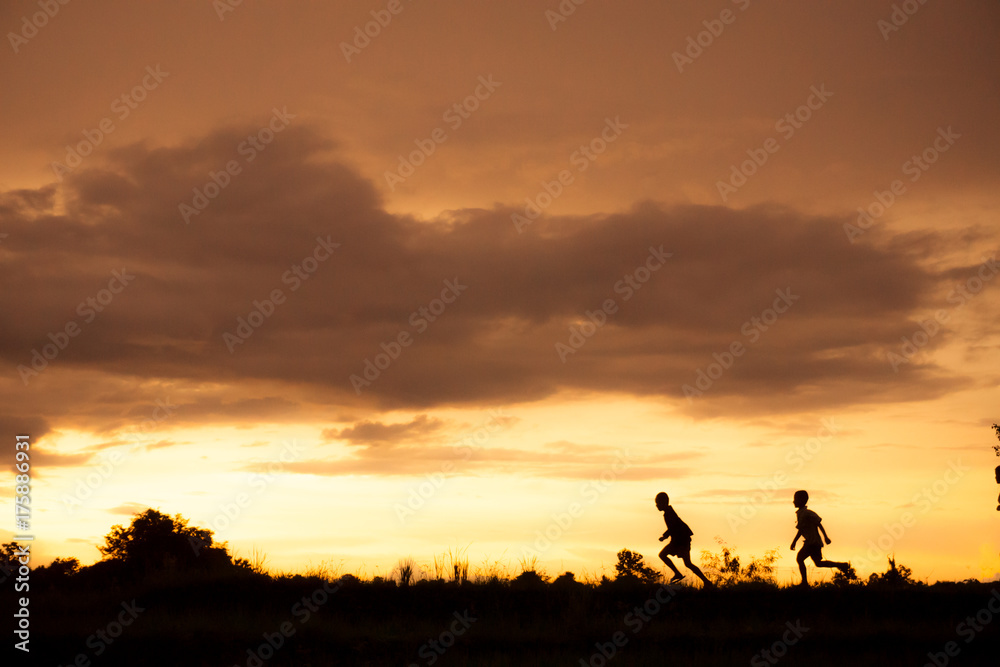 silhouette of a Boy playing on the sunset background