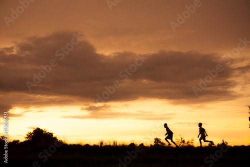 silhouette of a Boy playing on the sunset background
