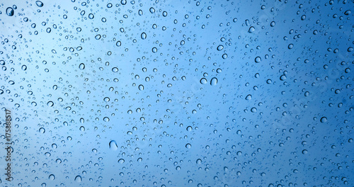 Rain drops on blue glass window background