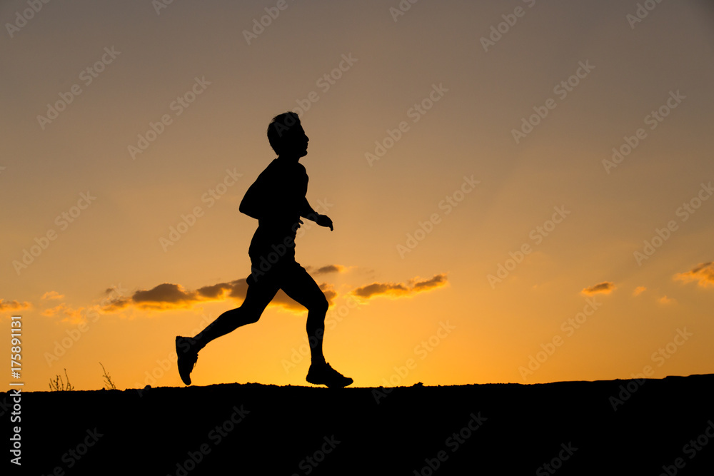 Silhouette of a man running at sunset