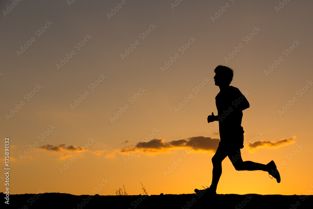 Silhouette of a man running at sunset