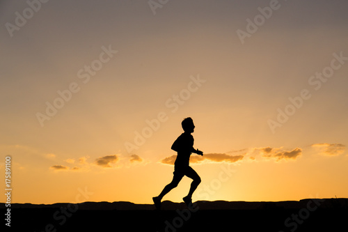 Fototapeta Naklejka Na Ścianę i Meble -  Silhouette of a man running at sunset