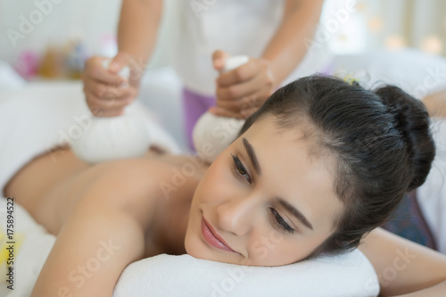 Young beautiful woman relaxing during massage in spa salon.