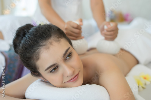Young beautiful woman relaxing during massage in spa salon.