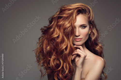 Fotografiet Portrait of woman with long curly beautiful ginger hair.