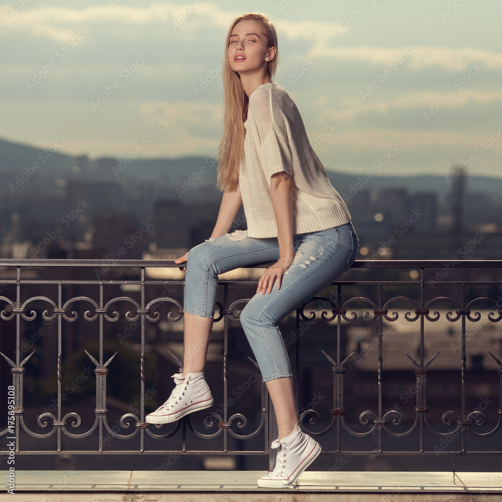 Fashion portrait of young blonde woman. Jeans and sneakers. Stock Photo | Stock