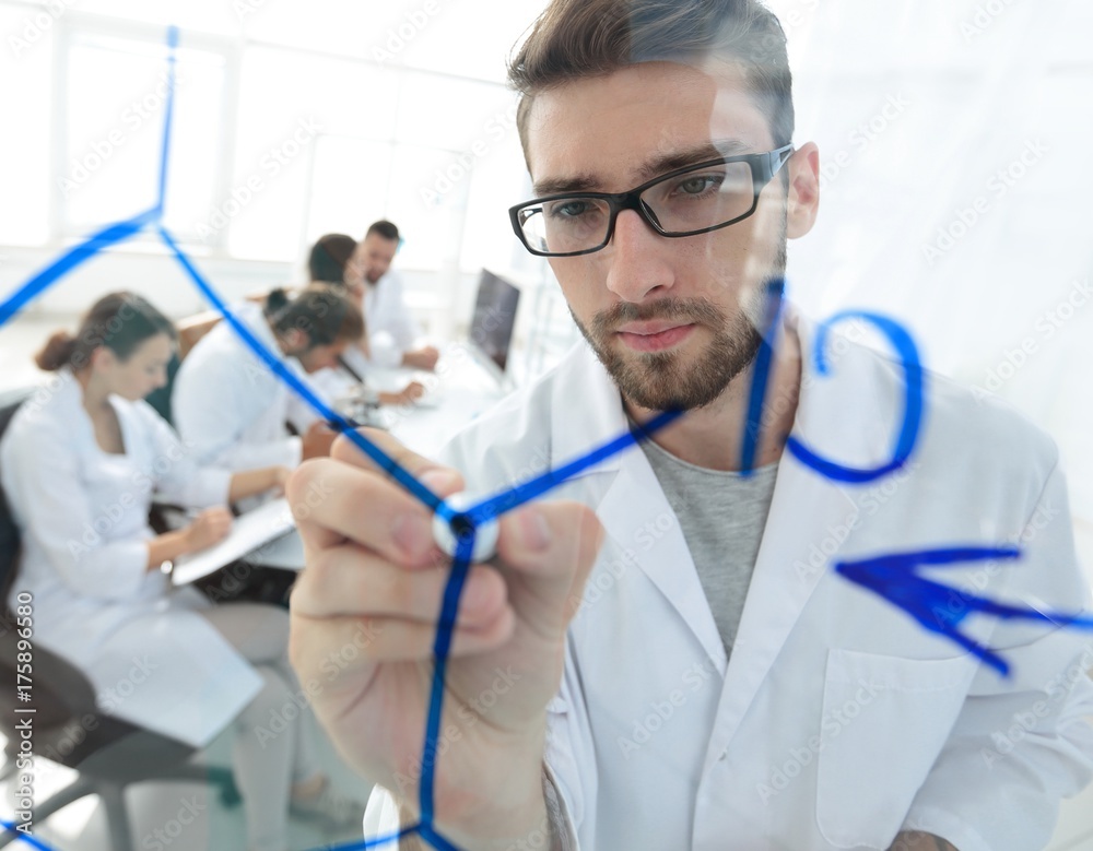from behind the glass.scientist writes a marker on a glass Board. from behind the glass.scientist writes a marker on a glass Board.