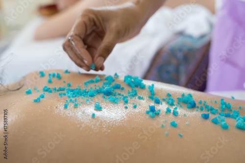 Beautiful young woman getting salt massage.