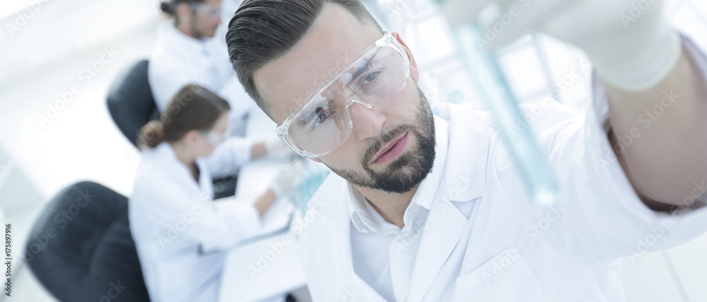 image is blurred. young scientist holding tube with the reagents image is blurred. young scientist holding tube with the reagents