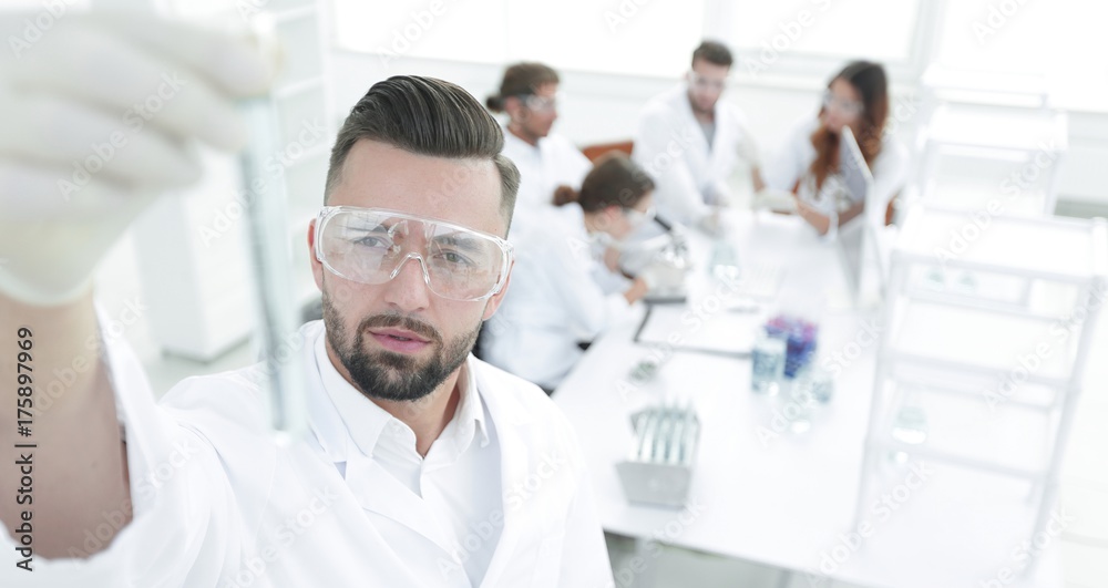 image is blurred. young scientist holding tube with the reagents image is blurred. young scientist holding tube with the reagents
