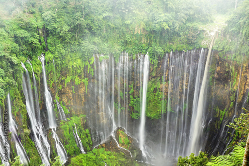 Multiple waterfalls flow down steep cliffs.