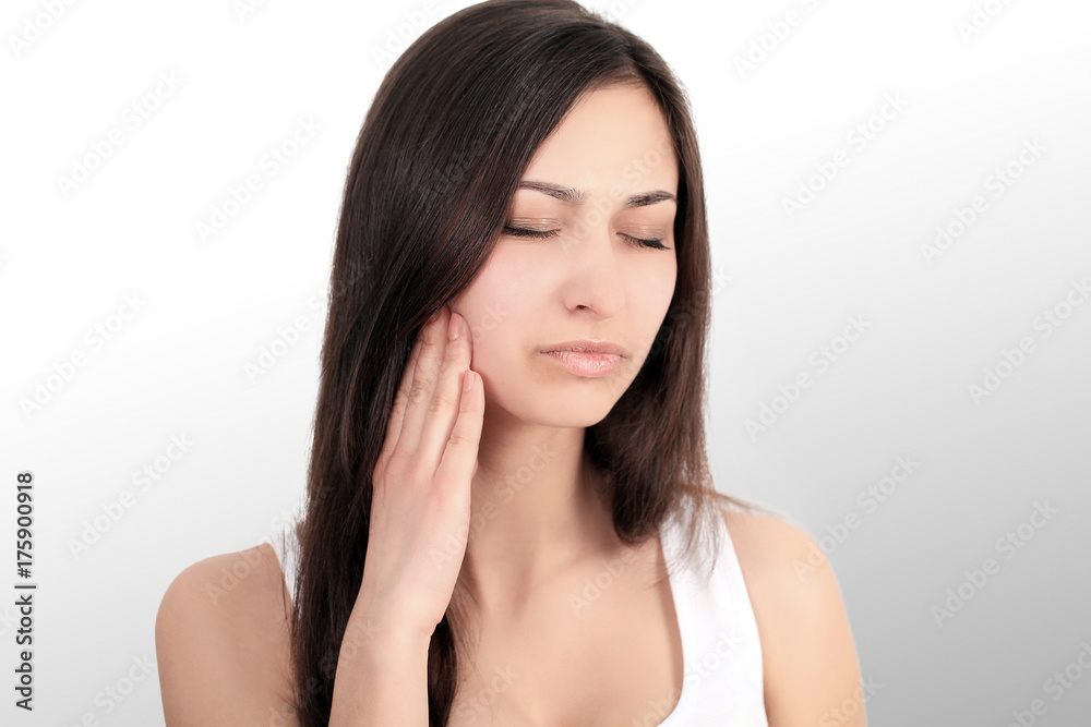 pretty girl with a strong headache on a grey backgroun pretty girl with a strong headache on a grey backgroun