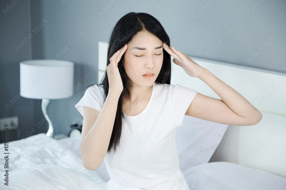 woman headache on bed in bedroom woman headache on bed in bedroom