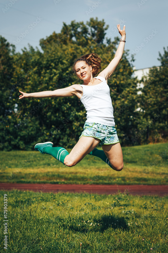 Female athlete does sport exercises in the stadium Female athlete does sport exercises in the stadium