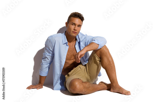 Foto Handsome Man Is Sitting In Unbuttoned Shirt In Sunlight