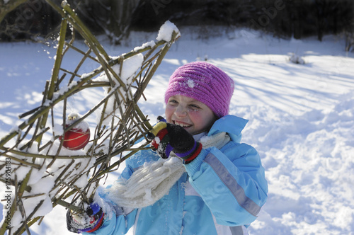 kleines Mädchen im Schnee hält selbstgemachten Stern