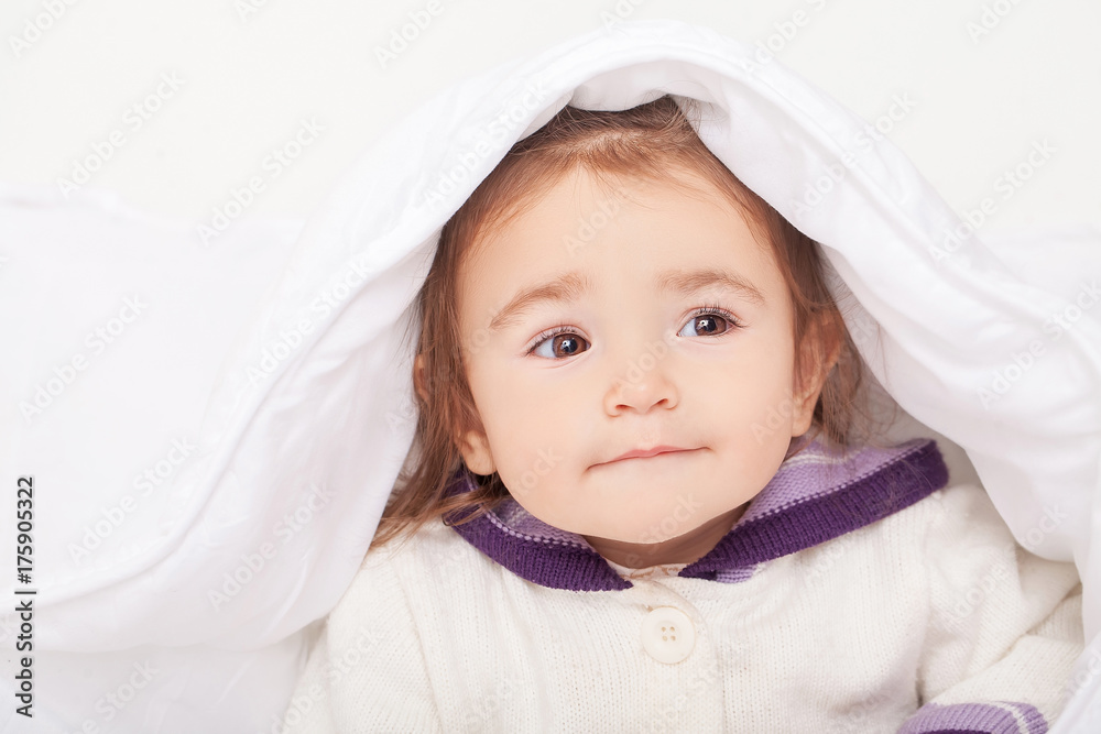 Portrait of baby girl lying in bed under featherbed Portrait of baby girl lying in bed under featherbed