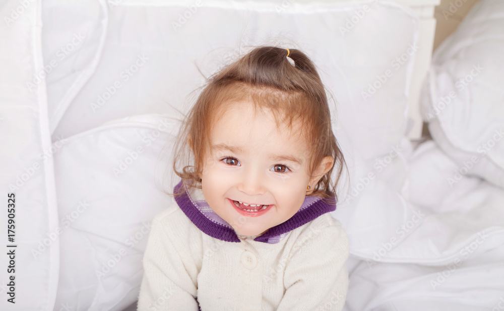 Portrait of baby girl lying in bed under featherbed Portrait of baby girl lying in bed under featherbed