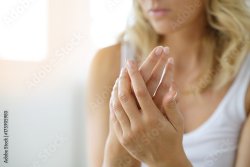 Closeup on woman's hands applying moisturizing hand-cream on