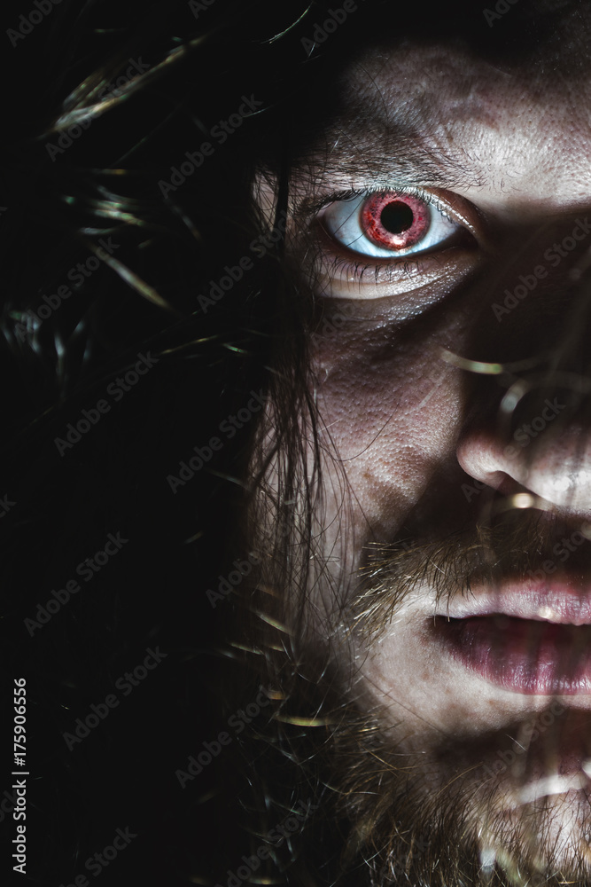 Portrait of a man with a red eye for horror or halloween.