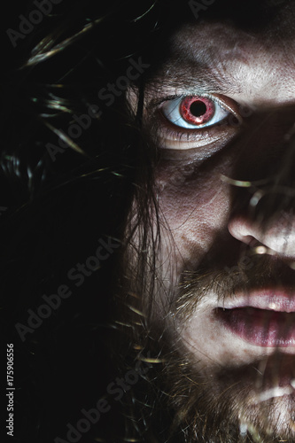 Portrait of a man with a red eye for horror or halloween.