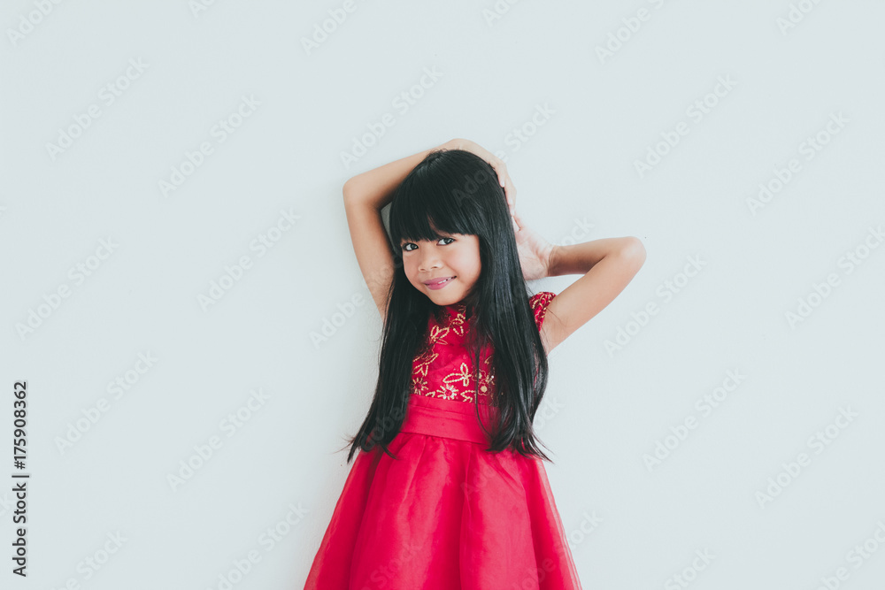 A cute asian kid girl wearing red Chinese dress for Chinese New year A cute asian kid girl wearing red Chinese dress for Chinese New year