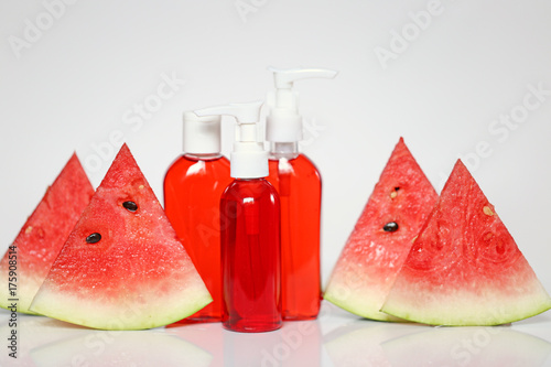 Cosmetic foam and gel for washing with a watermelon extract .  gel and foam in plastic tubes and pieces of watermelon on a light background. Organic Cosmetics Concept
