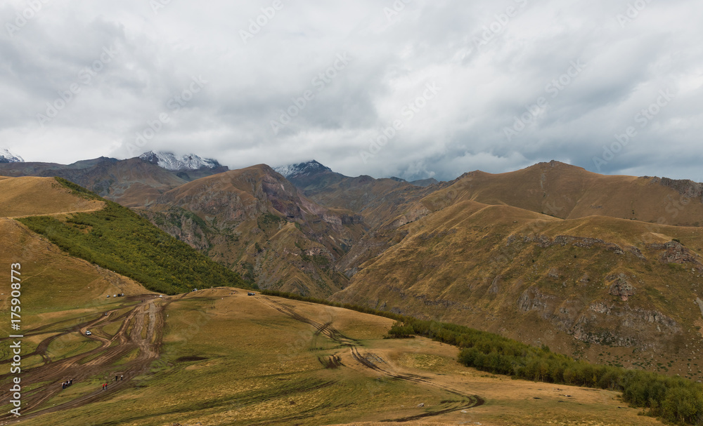 Panorama of Caucasian mountains near Gergeti Trinity Church, village of Gergeti and Stepancminda in Georgia.