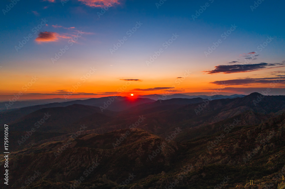 Sunset over mountain hills, aerial panoramic view
