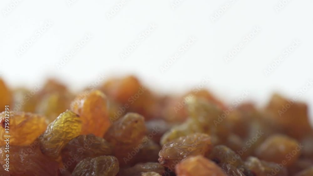 Golden dry raisins in wooden bowl are rotating close up Golden dry raisins in wooden bowl are rotating close up