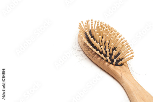 Wooden hairbrush with hair fallen isolated on white background