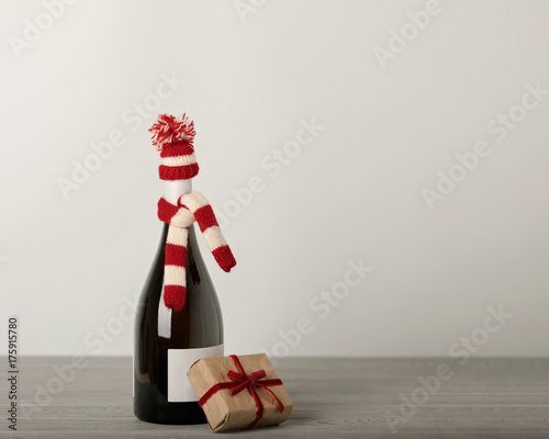Merry Christmas and a Happy New Year! Bottle of wine in a knitted cap of Santa Claus.