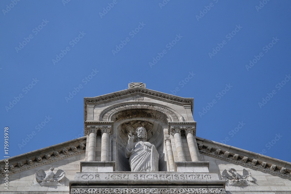 Majestic statue of Jesus blessing, French architectural detail of Sacred Heart Basilica, on Montmartre, in Paris