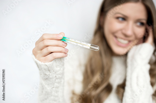  attractive girl in white sweater with thermometer happy recovered